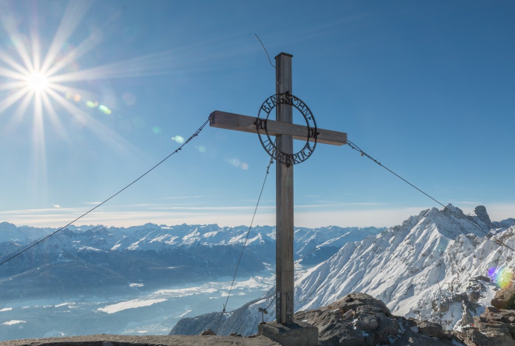 [Photo: On a peak of the Alps in Innsbruck, Austria, a massive cross is erected to consecrate and sanctify the surrounding wilderness. Source: Myself]